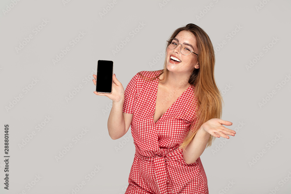 Smiling young woman holding mobile phone . Smiling young woman holding mobile phone .