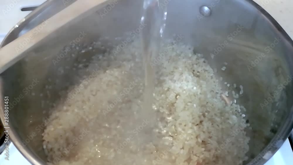 Frying rice in the pot before steaming it Frying rice in the pot before steaming it