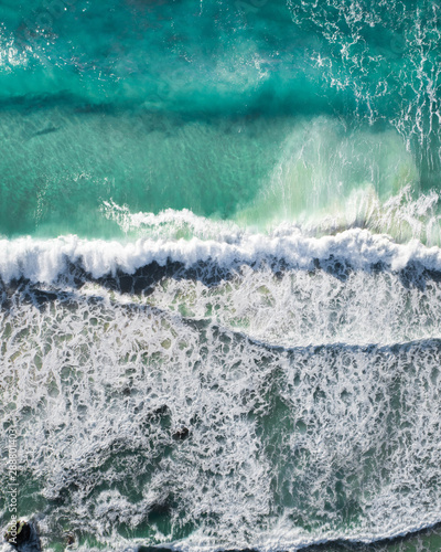 Aerial of a beach with waves at sunset with nice tones and warm summer vibes.