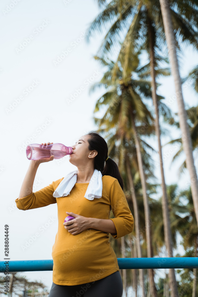 pregnant woman drink water bottle while workout outdoor pregnant woman drink water bottle while workout outdoor