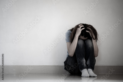 sad woman hug her knee and cry. Sad woman sitting alone in a empty room. photo