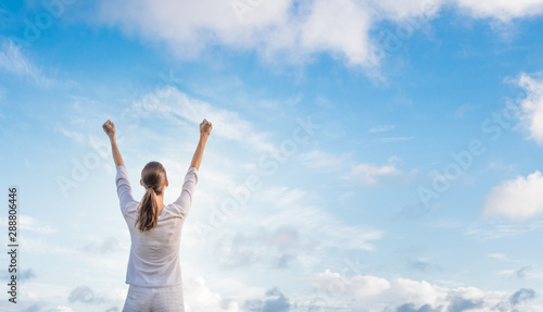 Happy woman feeling energized standing outdoors on a sunny day.