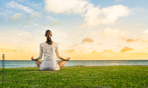 Wallpaper Mural young woman meditating by the sea at sunset Torontodigital.ca