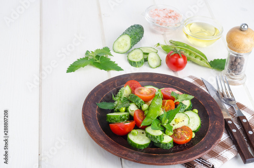 Fresh cucumber, tomato, green peas on ceramic bowl.