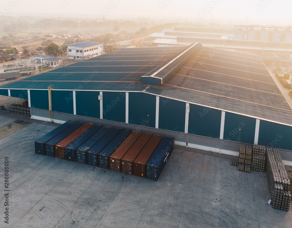 Φωτογραφία Aerial shot of a big warehouse near big metal containers at daytime