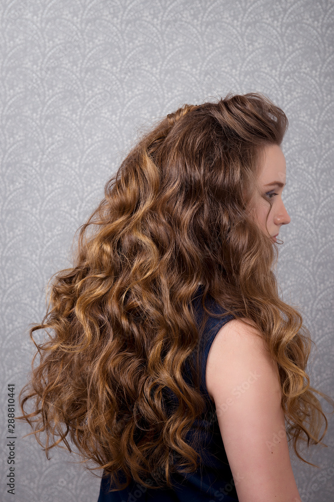 Naklejka premium Female hairstyle long curls close-up rear view.