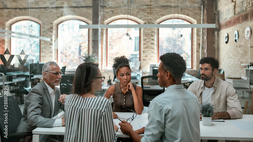 Important meeting. Group of business people discussing something and working together while sitting at the office table photo