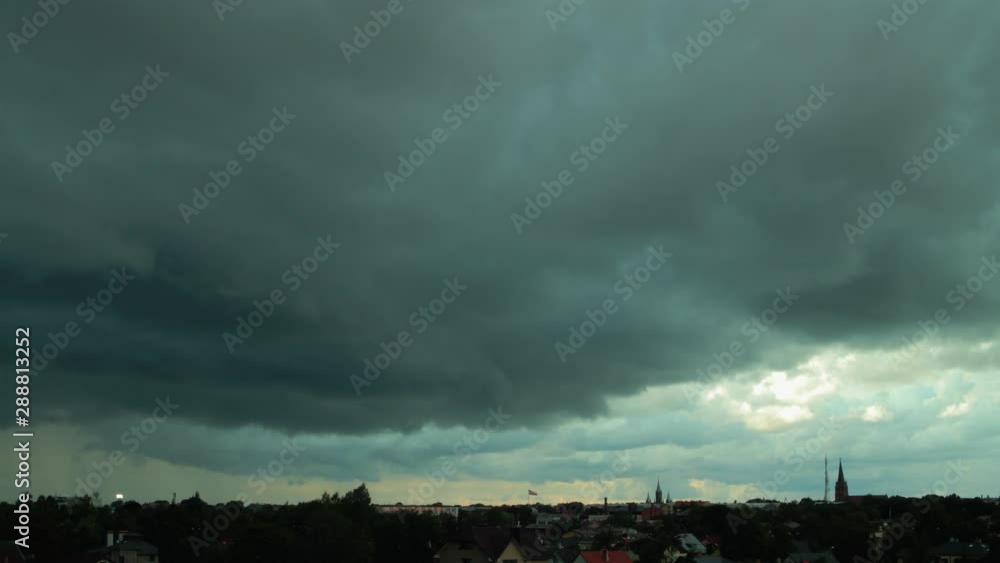 Time lapse of dark dramatic fast moving storm clouds over the city, medium shot Time lapse of dark dramatic fast moving storm clouds over the city, medium shot