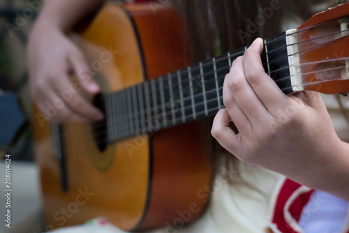 detalle de una mano y una guitarra, tocando cueca para fiestas patrias 