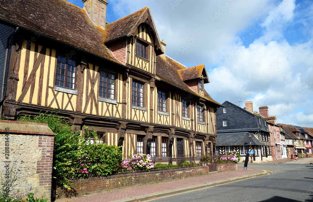 Beuvron-en-Auge, France - July 11, 2016: Beuvron is an achetpical small beautiful village in Normandy, France well-knowm by its half-timbered buildings. Beuvron-en-Auge, France - July 11, 2016: Beuvron is an achetpical small beautiful village in Normandy, France well-knowm by its half-timbered buildings.