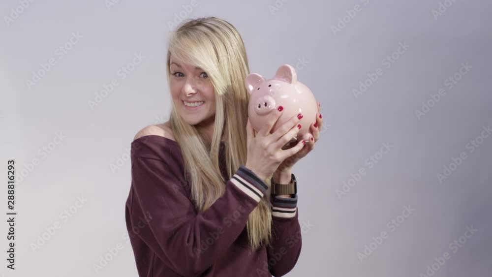 Woman displaying her fiscal responsibility with piggy bank Woman displaying her fiscal responsibility with piggy bank