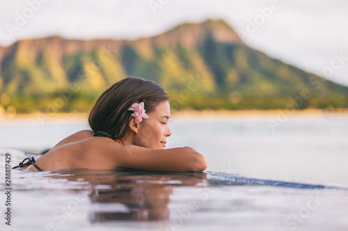 Cuadro en lienzo Luxury resort wellness pampering spa lifestyle Asian woman relaxing in infinity swimming pool of outdoor hotel on Waikiki beach, Honolulu, Hawaii travel