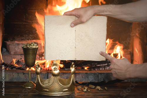 Royal decree or order book mockup in a king hands over burning fire background. photo