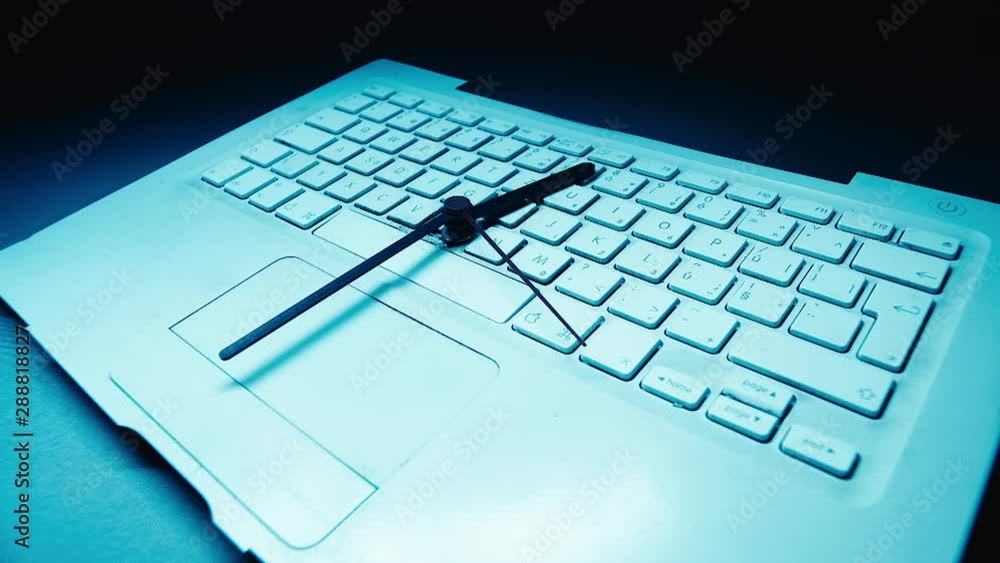 Clock hands turn swiftly in time lapse on a computer keyboard. Abstract, time spent in front of screen. Clock hands turn swiftly in time lapse on a computer keyboard. Abstract, time spent in front of screen.