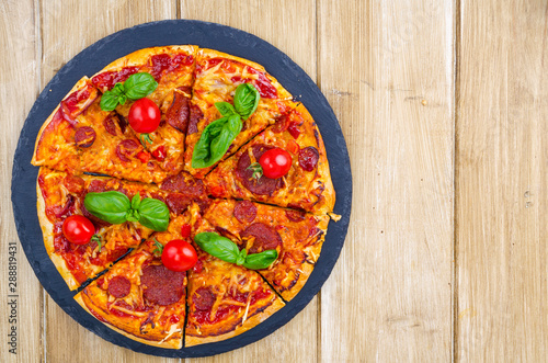 Pizza with salami, cheese and fresh vegetables
