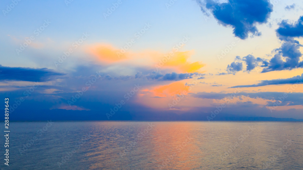Beautiful sunset on a lake in the mountains. Kyrgyzstan, Issyk-Kul Lake. Bright sky, background in warm colors. Beautiful sunset on a lake in the mountains. Kyrgyzstan, Issyk-Kul Lake. Bright sky, background in warm colors.