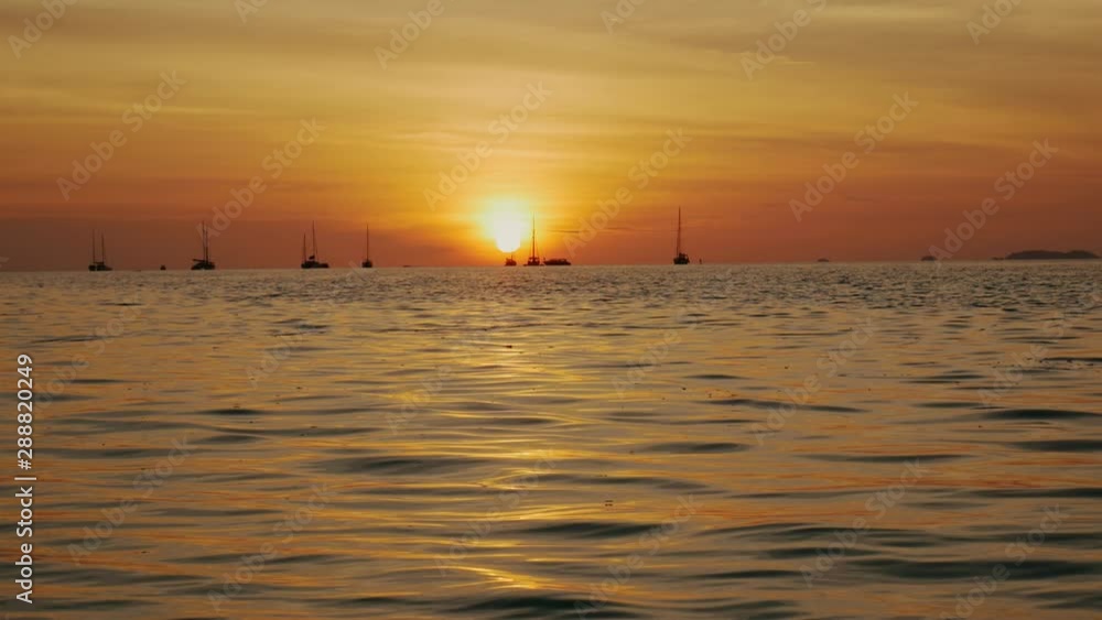 Sunset on the beach scene of a golden sunset over the sea, waves slowly splashing Sunset on the beach scene of a golden sunset over the sea, waves slowly splashing