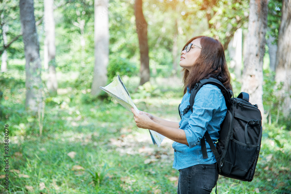 Woman traveller using map in green natural park trekking alone happy, carefree enjoy backpack outdoor lifestyle. Asian woman traveler wanderlust in dream destination with backpack hipster journey Woman traveller using map in green natural park trekking alone happy, carefree enjoy backpack outdoor lifestyle. Asian woman traveler wanderlust in dream destination with backpack hipster journey