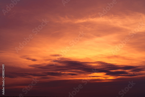 Beautiful sunset sky. Golden sky at sunset. Art picture of sky and dark clouds at dusk. Peaceful and tranquil concept. Twilight sky in evening. Background for life quote. Red, orange and dark clouds.