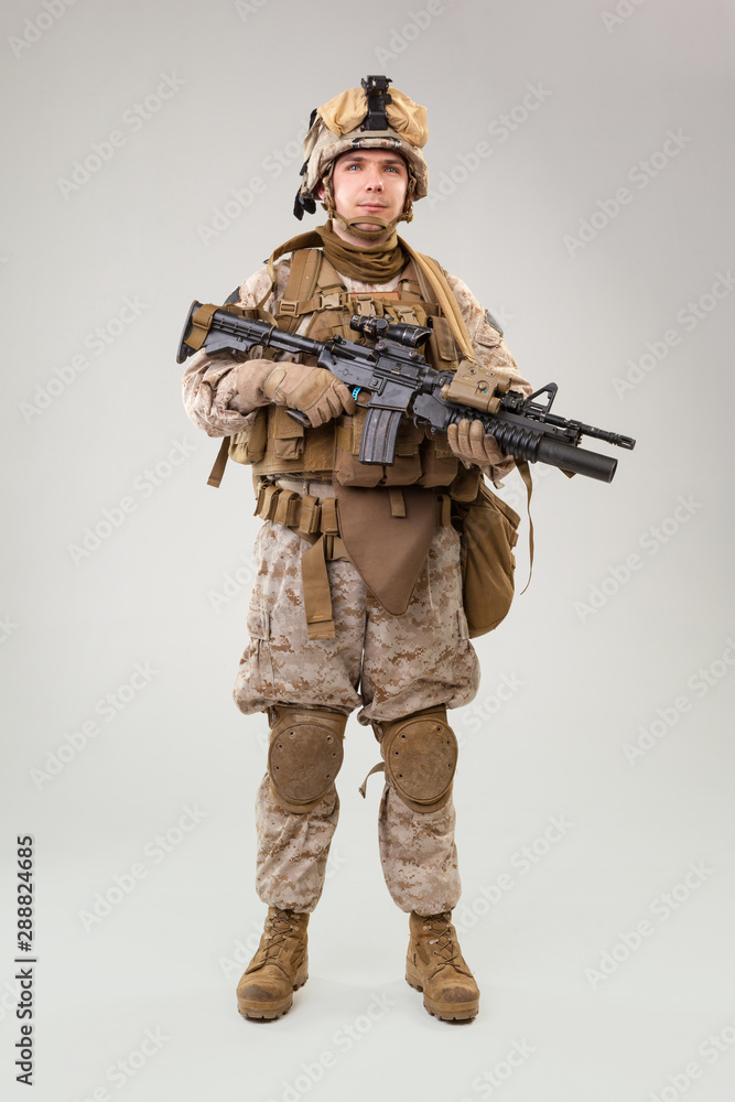 Portrait of a young American US Marine Corps soldier over grey background Portrait of a young American US Marine Corps soldier over grey background