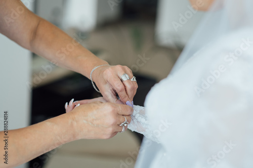 Bridesmaid preparing bride for the wedding day. Best morning. Wedding concept