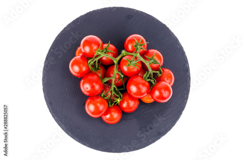 Bunch of red cherry tomatoes on black stone plate