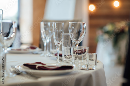 Glasses  flower fork  knife served for dinner in restaurant with cozy interior