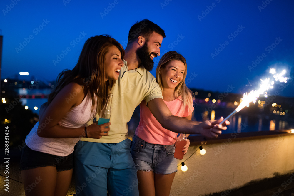 Group of young people having fun at a summertime party, at sunset