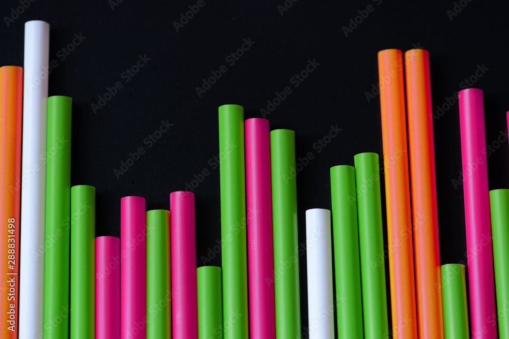 Plastic straws different colors on a dark background close up Plastic straws different colors on a dark background close up
