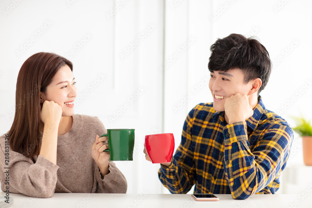 Happy young couple talking and laughing, drinking tea. Happy young couple talking and laughing, drinking tea.