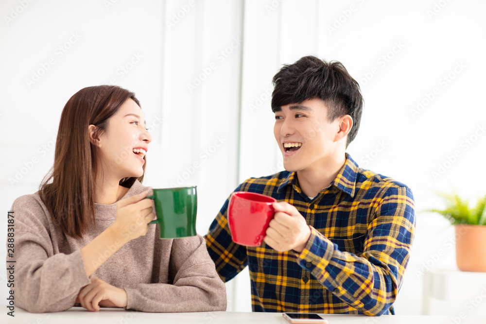 Happy young couple talking and laughing, drinking tea. Happy young couple talking and laughing, drinking tea.