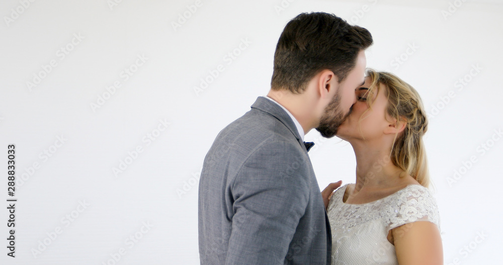 Fototapeta premium The lovers give flowers to the bride and kissed happy and couple love standing in wedding studio