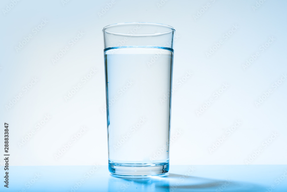 Glass of water on blue background. Refreshing drink Glass of water on blue background. Refreshing drink