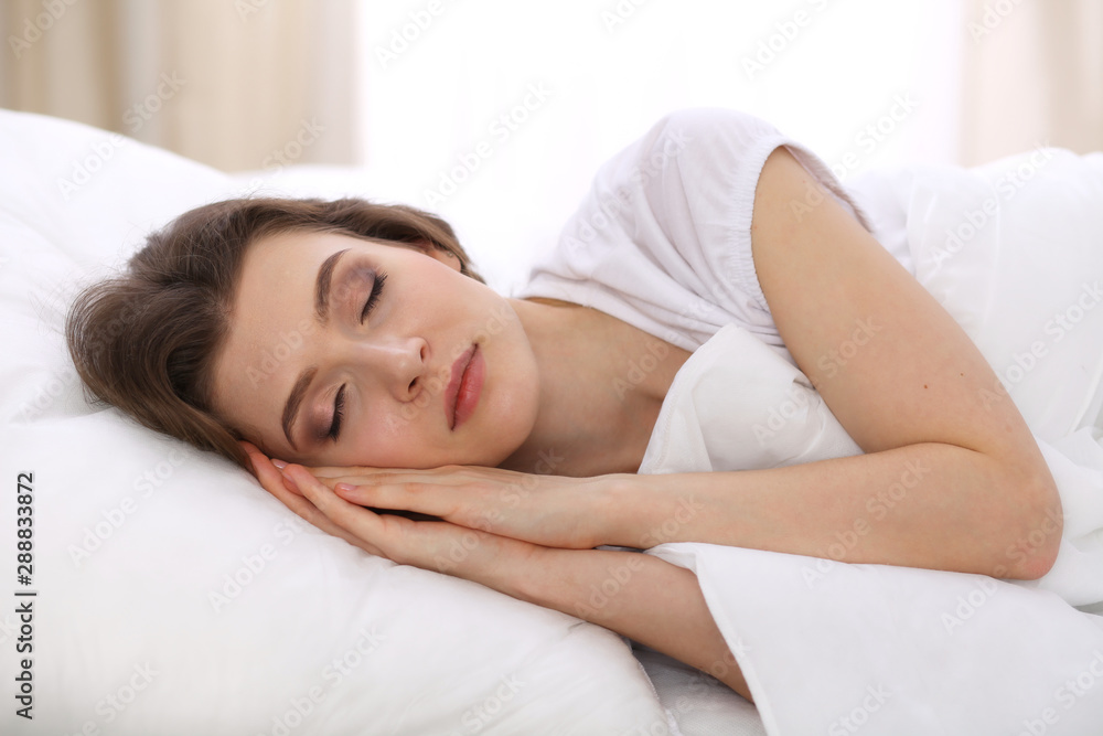 Beautiful young woman sleeping while lying in her bed. Concept of pleasant and rest reinstatement for active life Beautiful young woman sleeping while lying in her bed. Concept of pleasant and rest reinstatement for active life