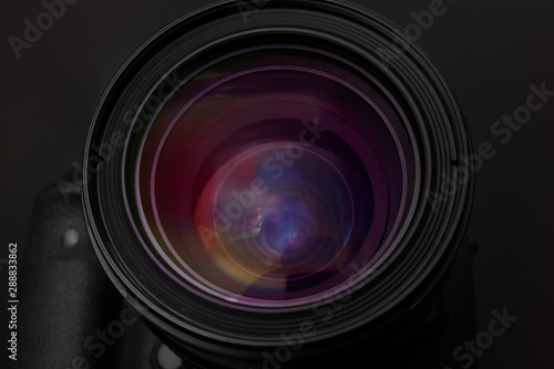 Lens of professional camera on black background, closeup