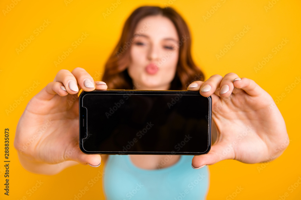 Photo of lady holding telephone making self photos with coquette kisses wear tank-top isolated yellow background