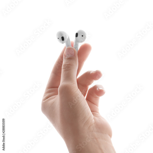 Woman holding modern wireless earphones on white background, closeup