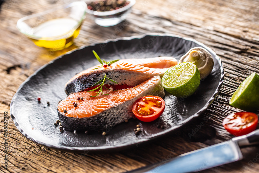 Salmon raw steaks rosemary tomatoes mushroom lime olive oil and spices. Salmon raw steaks rosemary tomatoes mushroom lime olive oil and spices.