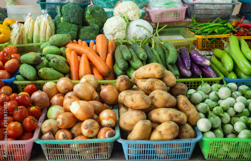 Thai market grocery - carrots, potatoes, onion, mango, tomatoes, eggplants, chile, cauliflower, broccoli, ears of corn