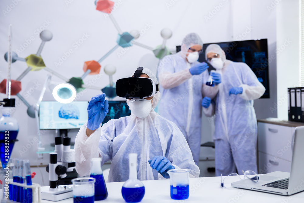 Fototapeta premium Female scientist using virtual reality goggles simualtion for chemical experiment