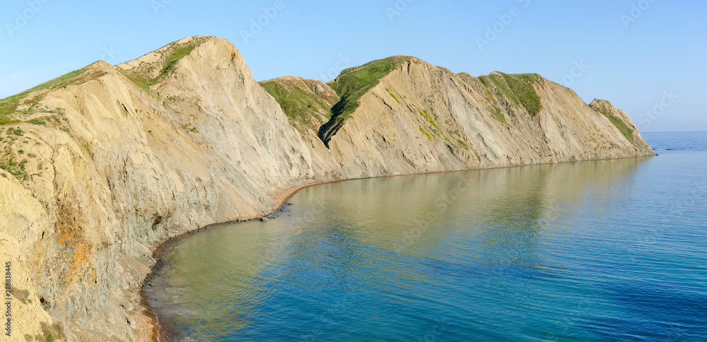Textured clay promontory on the sea shore, panoramic view