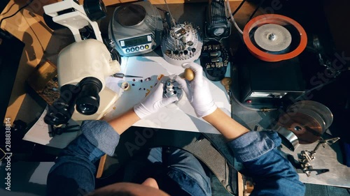 One jeweller uses a tool while working with a ring. photo