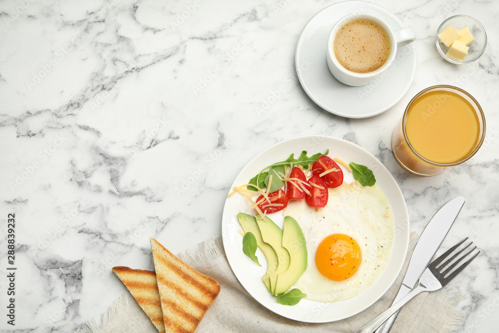 Tasty breakfast with fried egg served on white marble table, flat lay. Space for text Tasty breakfast with fried egg served on white marble table, flat lay. Space for text