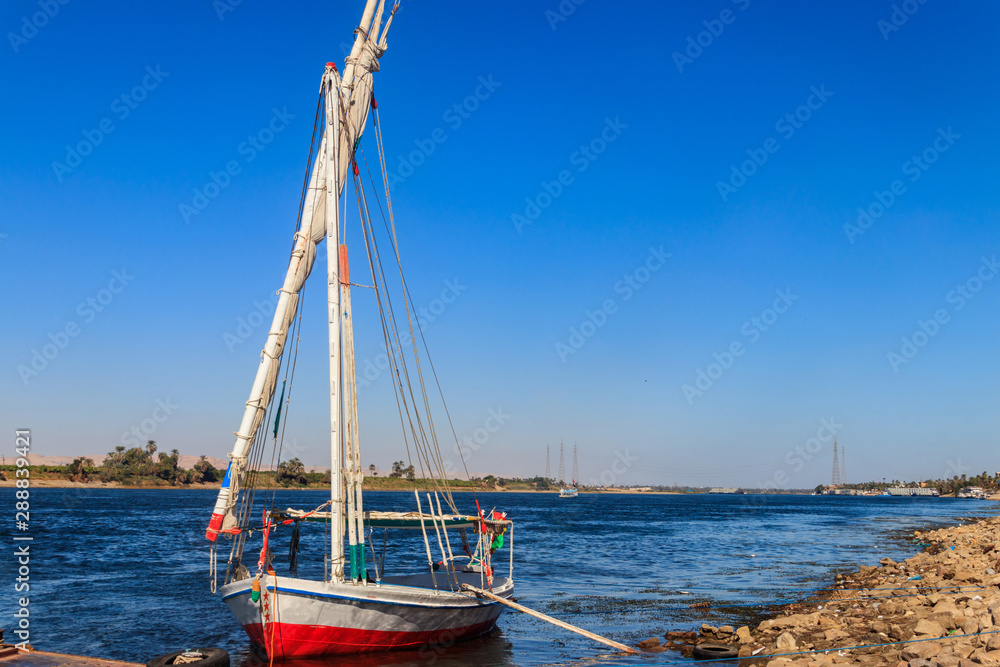 Felucca boat moored near the shore of Nile river in Luxor, Egypt