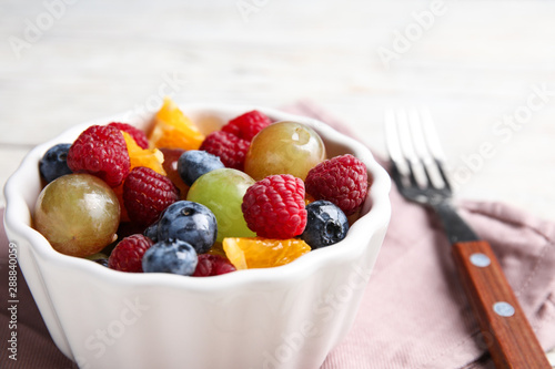 Fresh tasty fruit salad on table  closeup