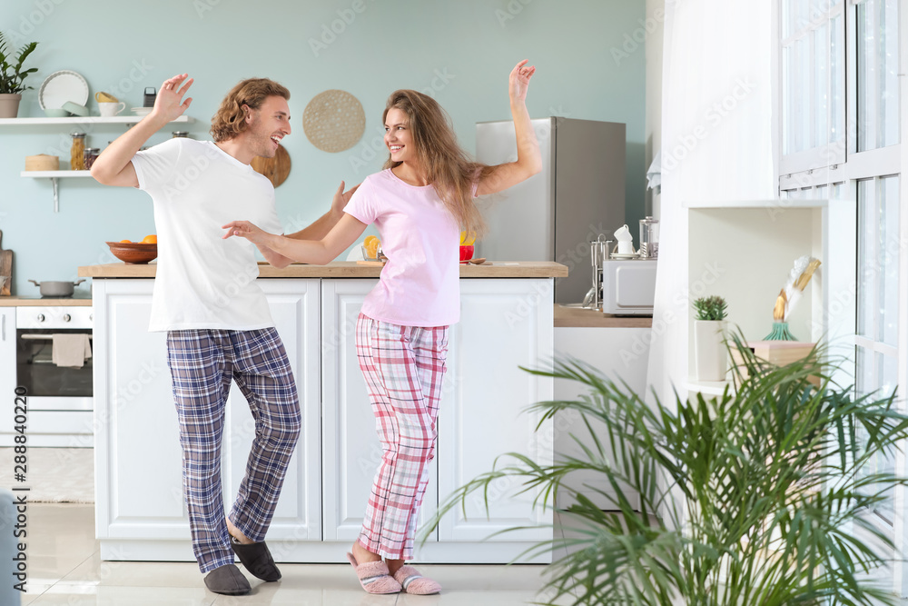 Fotografie Happy young couple dancing in kitchen