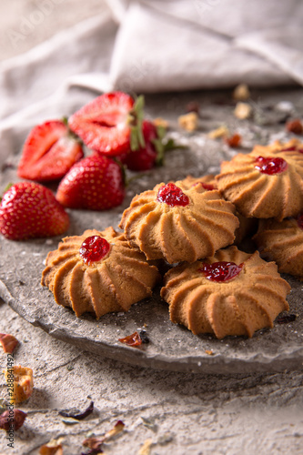 Biscuit with strawberry filling. Crispy and crumbly delicious cookies with natural ingredients: flour, nuts, seeds, pieces of chocolate, cocoa, fruit jams. Spring Flower Still Life