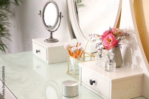 Fotografering Modern dressing table with flowers in stylish room interior