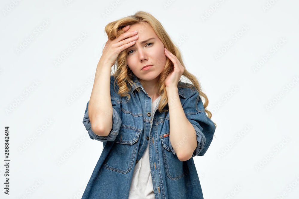 Young caucasian woman puts hands on the head, having a terrible pain. Concept of problems and headache Young caucasian woman puts hands on the head, having a terrible pain. Concept of problems and headache