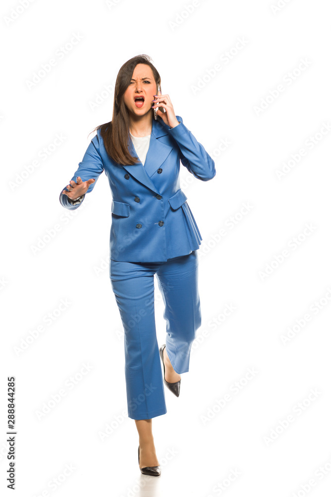 young business woman running and talking on the phone on a white background young business woman running and talking on the phone on a white background